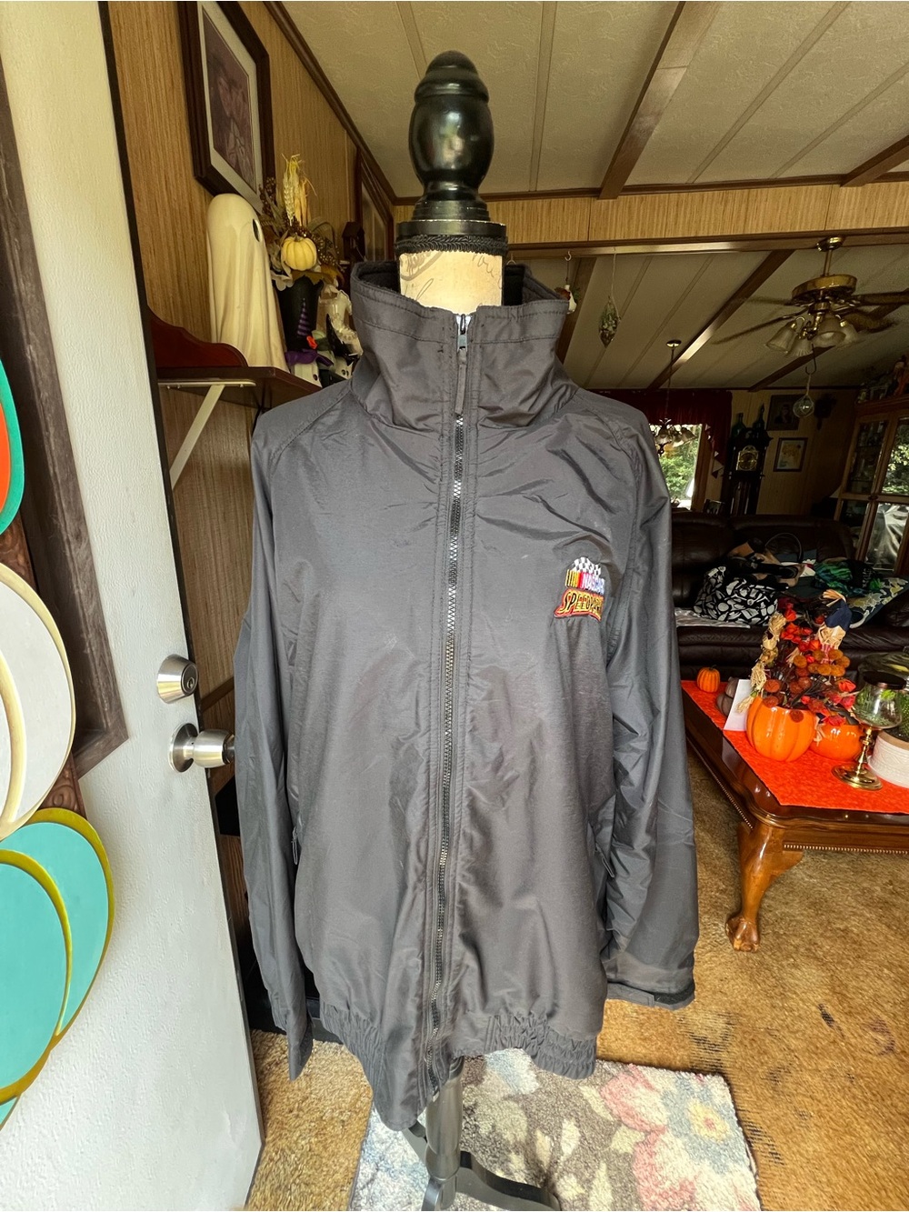 Vintage black NASCAR windbreaker jacket with a high-neck collar, full zip-up.
